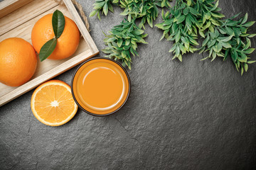 Fototapeta na wymiar Fresh orange juice in glass dark stone background. Copy space for text