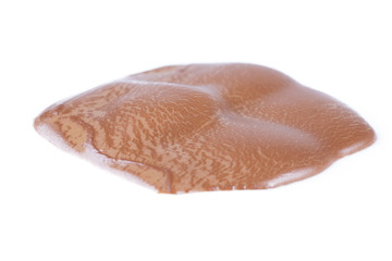 Melting piece of dark chocolate on white background.