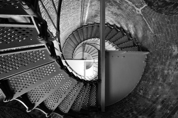 B&W View Looking Up Through Spiral Stair Case In Brick Tower