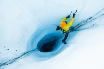 Ice flying from an ice ax swing while on lead out of a moulin on the Matanuska Glacier, Alaska - obrazy, fototapety, plakaty