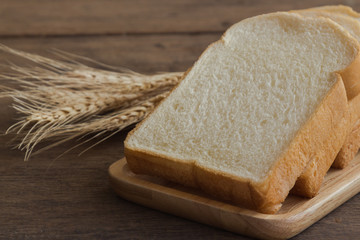 Sliced bread stack on wood plate. Homemade bread for breakfast put on rustic wood table. Soft and sticky homemade bread for delicious toast in breakfast. Homemade bakery background with copy space.
