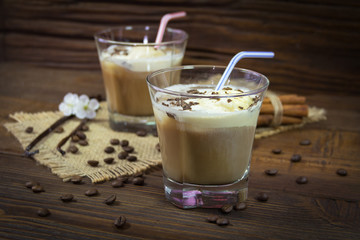 Two glasses of refreshing ice coffee on a wooden background