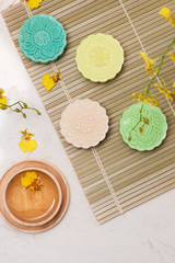 Sweet color of snow skin mooncake. Traditional mid autumn festival foods with tea on table setting.
