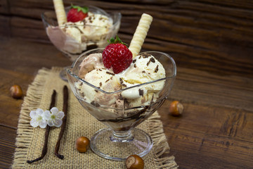 Vanilla, chocolate and haselnut ice cream in a bowl on wooden background