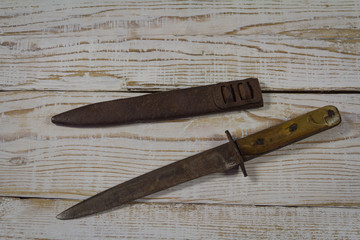Old bayonet with scabbard on wooden background