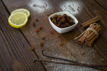 Raisins spilled from a bowl on the wooden table