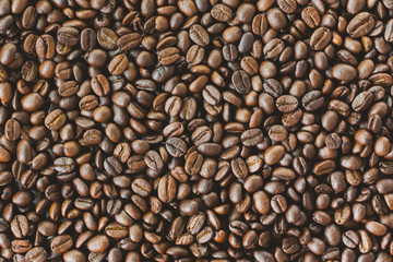 Stack of roast coffee beans. Close up of coffee beans concept for background and wallpaper. Macro concept for background and texture. Copy space of coffee beans on rustic wood table for background.