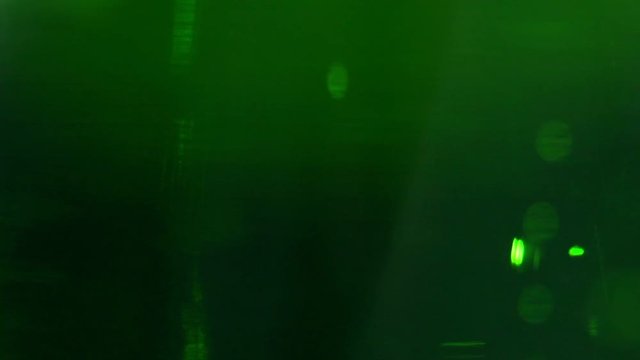 Liquid is bright green in glass chemical flask: texture and processes of venturi. In vitro: liquid in chemical container extra close-up. Reagents in chemical containers: colored chemical experiments.