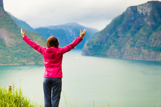 Woman with raised hands in norwegian mountains fjords