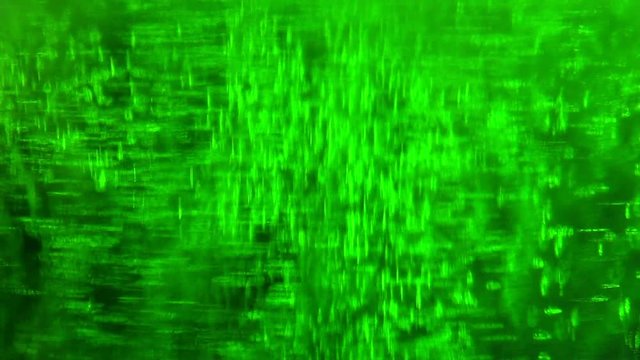Liquid is bright green in a glass chemical flask: texture and processes of venturi. In vitro: liquid in chemical container extra close-up. Reagents in chemical containers: colored chemical experiments