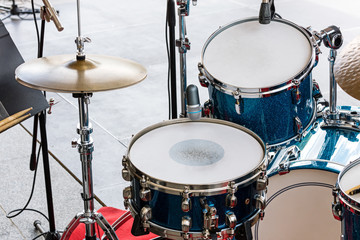 Obraz na płótnie Canvas set of drums, cymbals and microphones on pavement background closeup