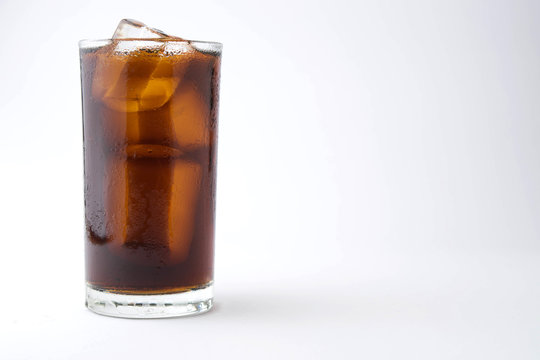 cola with ice in glass on white background with copy space