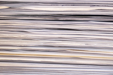 Stack of files full of documents signifying concepts such as work and stress, and business objects.