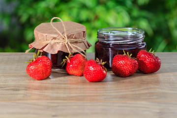 Traditional homemade strawberry jam in a jars, decorated with fresh strawberries
