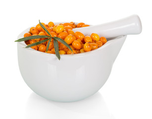 Ripe berries of sea-buckthorn in mortar with pestle isolated on white background.