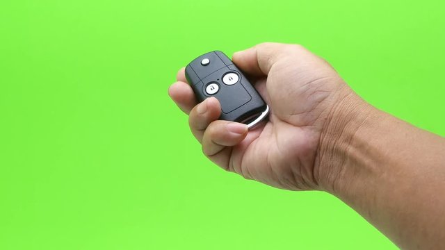 hand presses car keys on green screen