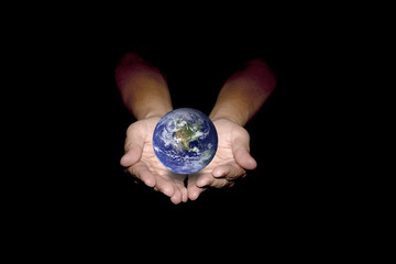 Blue earth in human hands isolated on black background.