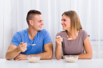 Young happy couple enjoys having breakfast together.