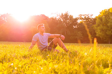Fototapeta premium A young man sitting in the Grass