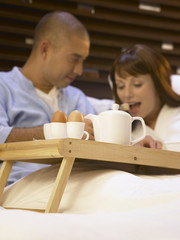 loving couple having a lazy morning breakfast in comfy bed