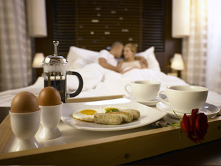 Fototapeta na wymiar couple in hotel room with breakfast ready for them