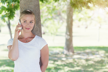 Portrait of young blonde woman talking on mobile phone