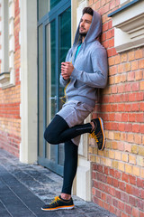 Young man next to a brick wall 