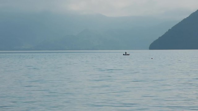 静かな朝の湖と釣り人