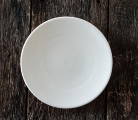 empty white plate on wooden