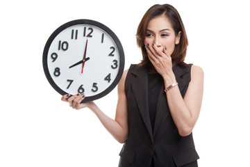 Sleepy young Asian woman with a clock in the morning.