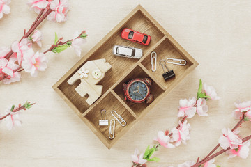 Top view business office desk concept. Wood house  also car and clock on wooden shelf.The beautiful pink flower on wood background with copy space.