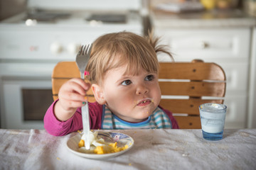 Little girl uses fork