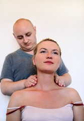 Fototapeta premium Massage professional studio. Spa treatment. Man relaxing getting neck and shoulder massage. Masseuse human hands massaging for neck. Smiling woman sitting and having neck massage in medical office.