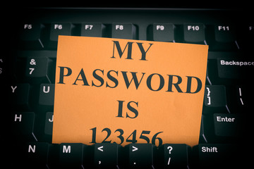 Paper note with easy password on black computer keyboard