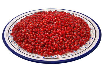 Grains of pomegranate on a traditional Tunisian plate, isolated