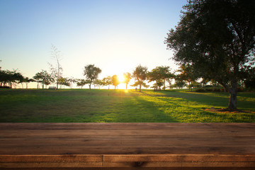 Empty wooden table in front of dreamy countryside sunset background