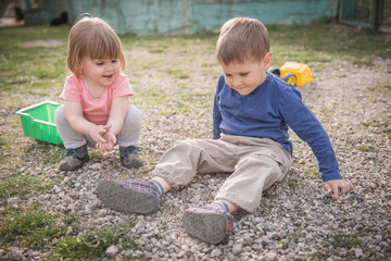 Smiling kids playing in yard with sones