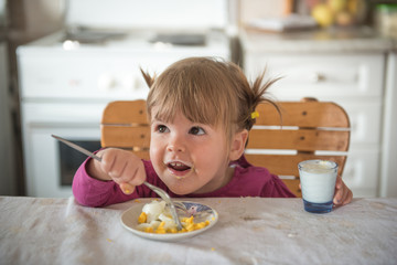 Happy little girl having breakfast