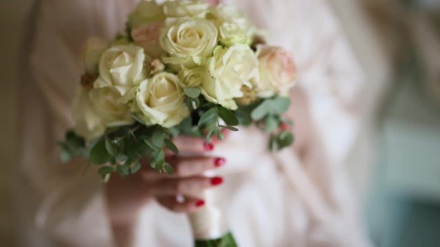 Bridal bouquet of roses and eucalyptus in the hands of the bride. Wedding in Montenegro.