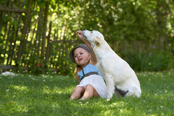 kleines Mädchen spielt mit Hund