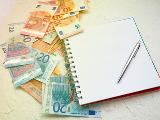 money Euro and a notebook with a pen, to dream, to record expenses, home finances, space for text