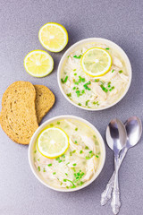Traditional Greek lemon orzo chicken soup on stone background. 