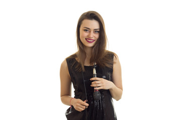 Beautiful woman in bright black dress smiling on camera with microphone on her neck