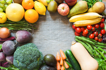 Different fruits vegetables, broccoli, carrots, avocado, tomatoes, beetroot, bananas, apples, pears, lemons, greens on the grey table selective focus