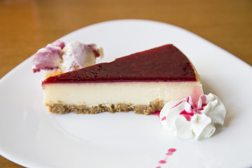 Fresh raspberry cheesecake on white plate 