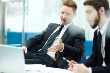 Co-working economists reading online financial data