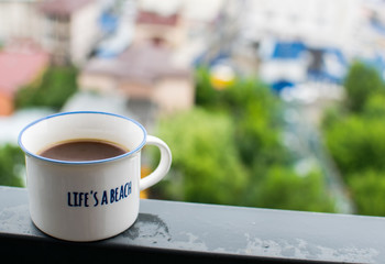 Coffee cup on steel beam, overlooking the city