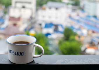 Coffee cup on steel beam, overlooking the city