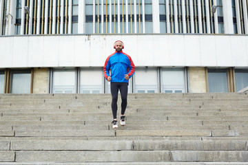 Sportsman descending staircase in urban environment