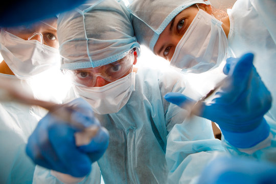 Surgeons holding instruments in hands
